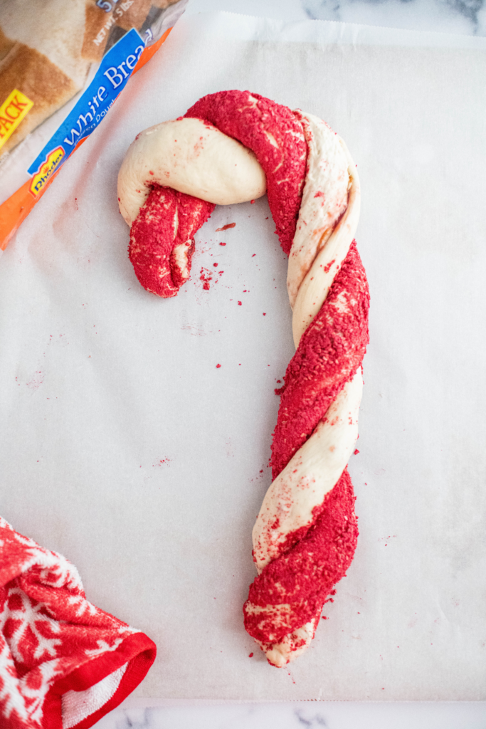 Unbaked twisted red and white candy cane bread.