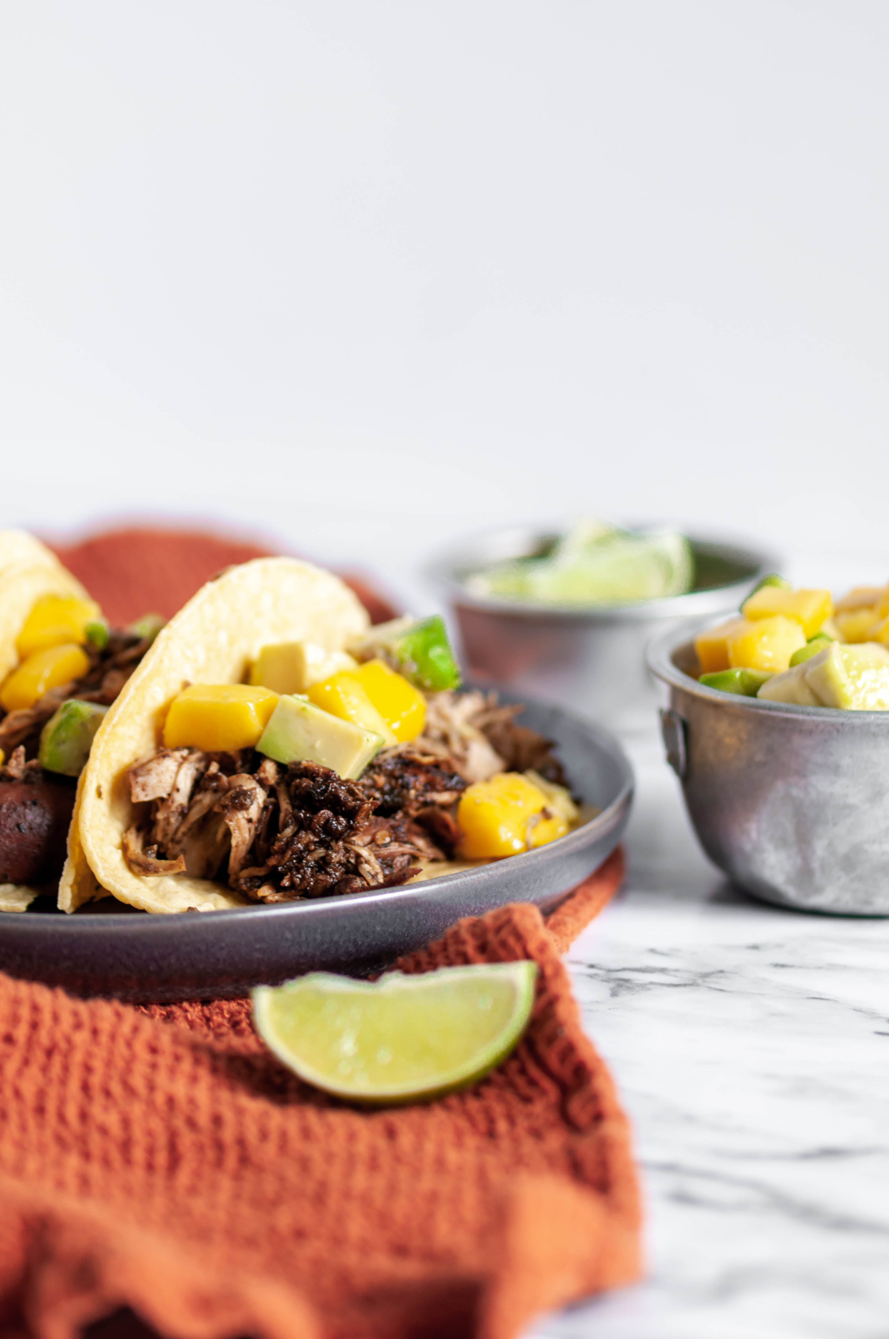 Slow Cooker Jerk Chicken Tacos are super simple and packed full of Caribbean flavor. Mango avocado salsa add some sweet freshness.