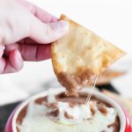 Slow Cooker Cheesy Bean Dip is the perfect addition to your football watch party. 4 ingredients mixed in your slow cooker, a few hours and you're ready for snacking. Homemade flour tortilla chips up your game.