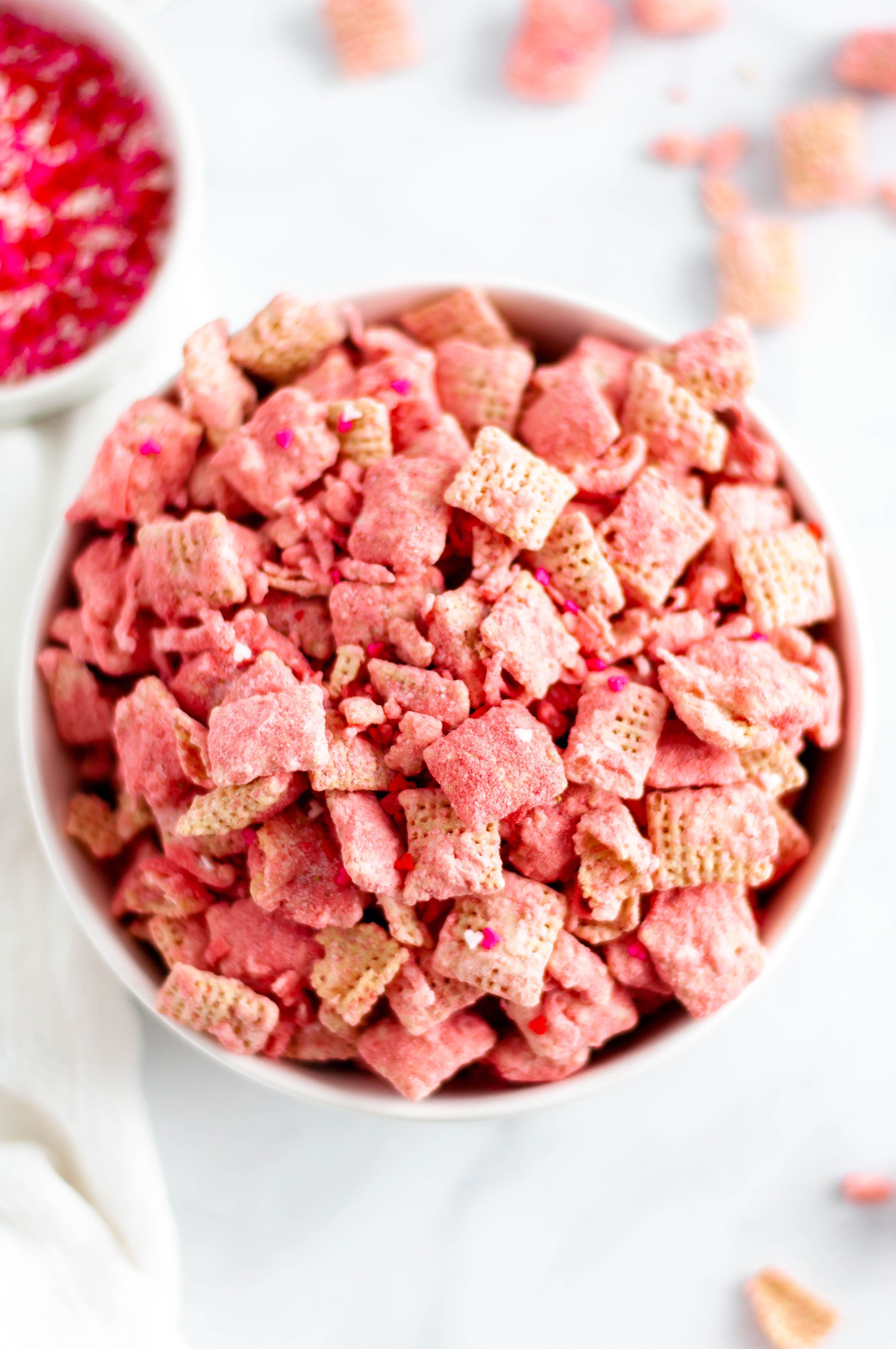 Make your Valentines Day festive with this Coconut Strawberry Puppy Chow. White chocolate, freeze dried strawberries & coconut are such a sweet combination.