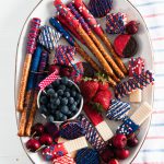 You'll be the hit of the 4th of July party when you show up with this Red White and Blue Dessert Board. Super simple to make with store-bought ingredients, some time and all your creative juices.