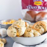 Make these simple, delicious, cheese stuffed Garlic Knots using Rhodes Bake-N-Serv Texas rolls for your next holiday dinner. Simple to make and taste homemade! Check out the step-by-step tutorial for these super simple rolls.