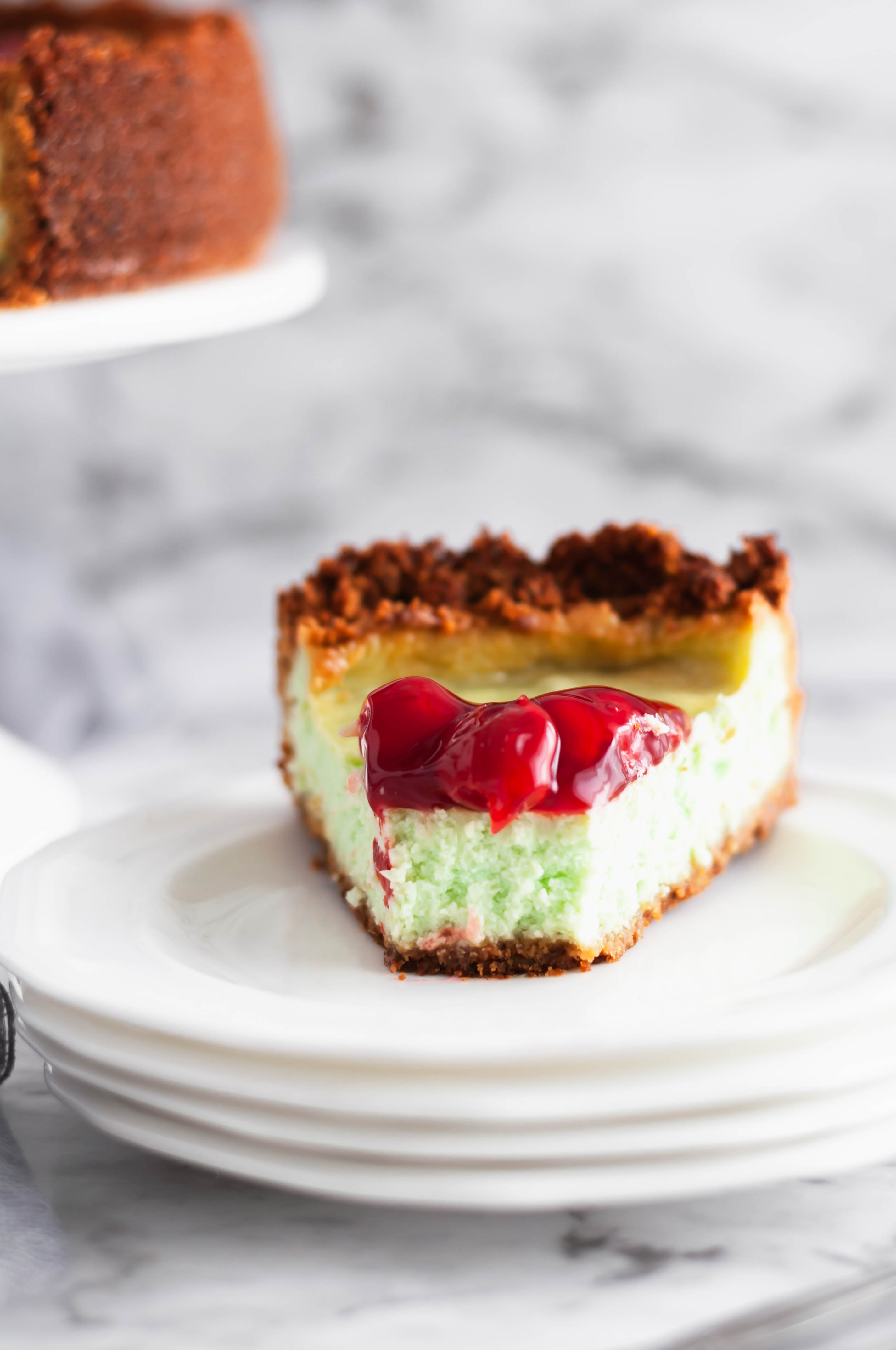 This PIstachio Cheesecake is a delightful holiday dessert. Thick, creamy cheesecake studded with pistachio flavor throughout the filling and crust. Top with cherries to make it extra festive.