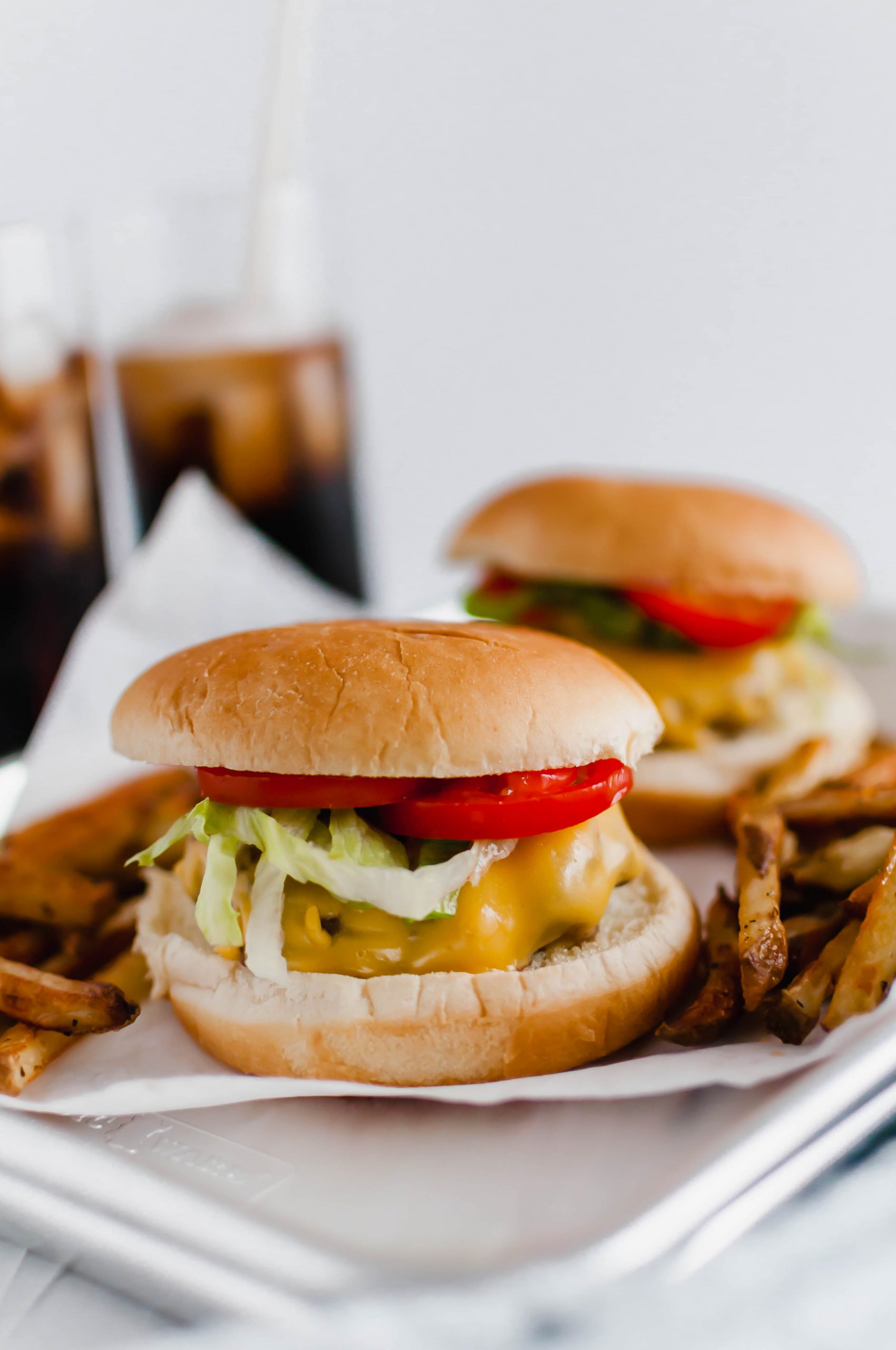 You don't need warm weather to enjoy a burger at home. These Sheet Pan Burgers and Fries are super simple to make all on one pan. A great, simple weeknight meal.