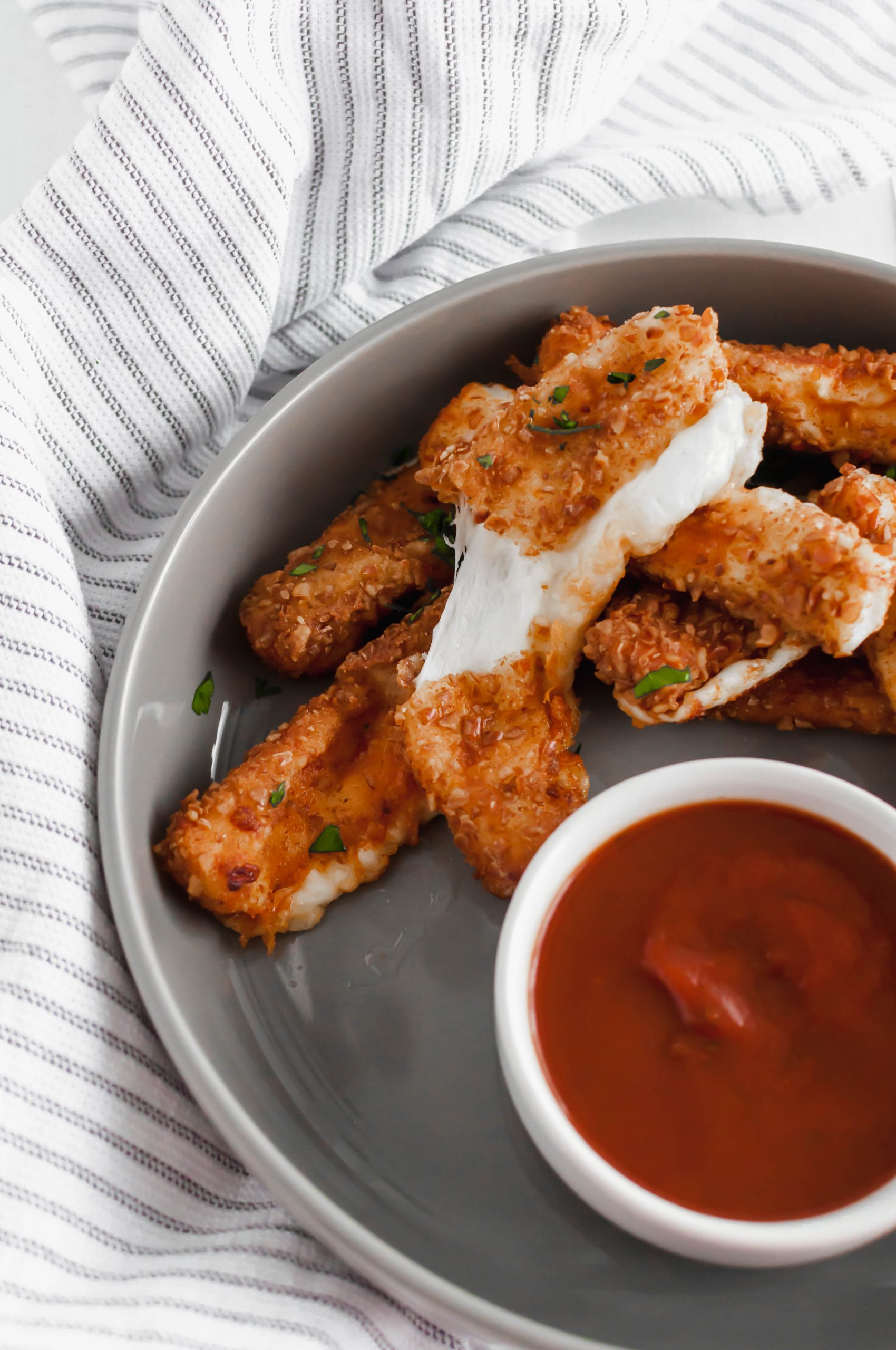 These Mozzarella Sticks with Pretzel Crumbs are the ultimate Super Bowl appetizer. Mozzarella cheese sticks covered in pretzels crumbs and fried to golden brown. Just look at that cheese pull.