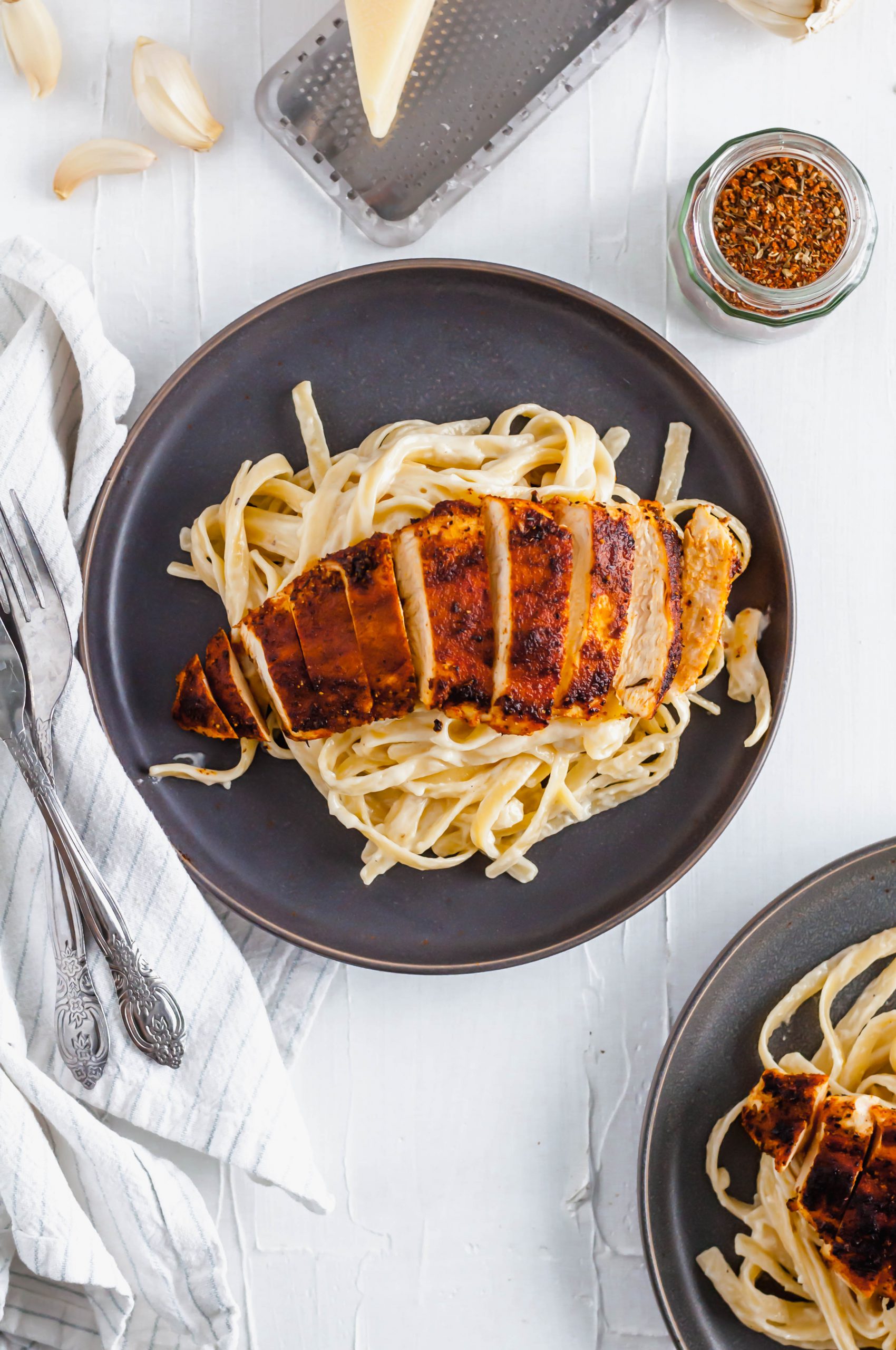 This Blackened Chicken Alfredo is the ultimate weeknight meal. Done in 30 minutes and packed with flavor. Easy enough for any weeknight but fancy enough for guests too. Homemade blackening seasoning covered tender chicken cutlets served over simple, cheesy homemade fettucine alfredo.