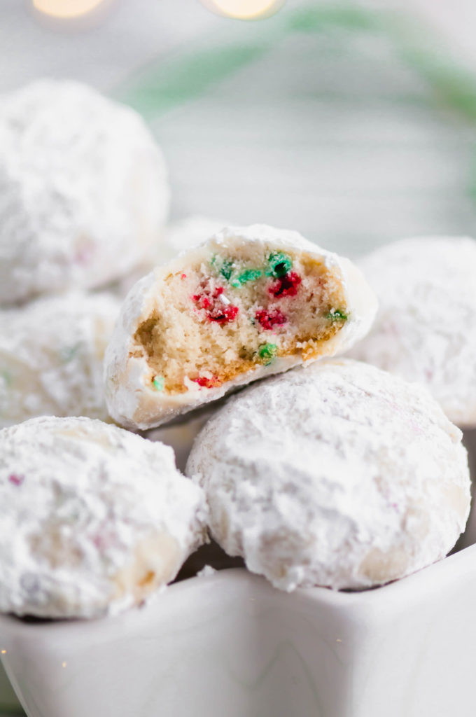 Tender, melt in your mouth Christmas Snowball Cookies are the perfect addition to your baking list this season. Super festive and fun.