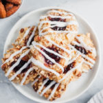 These Raspberry Thumbprint Cookies will quickly become your favorite Christmas cookie. Melt in your mouth cookies, rolled in chopped salted almonds, filled with raspberry jam and drizzled with glaze. The prettiest cookie to add to your Christmas cooking baking list