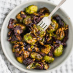 Honey Balsamic Brussels Sprouts are roasted perfectly in the oven then drizzled with the tastiest sweet and savory sauce. Topped with crispy bacon and pumpkin seeds for the perfect crunch.