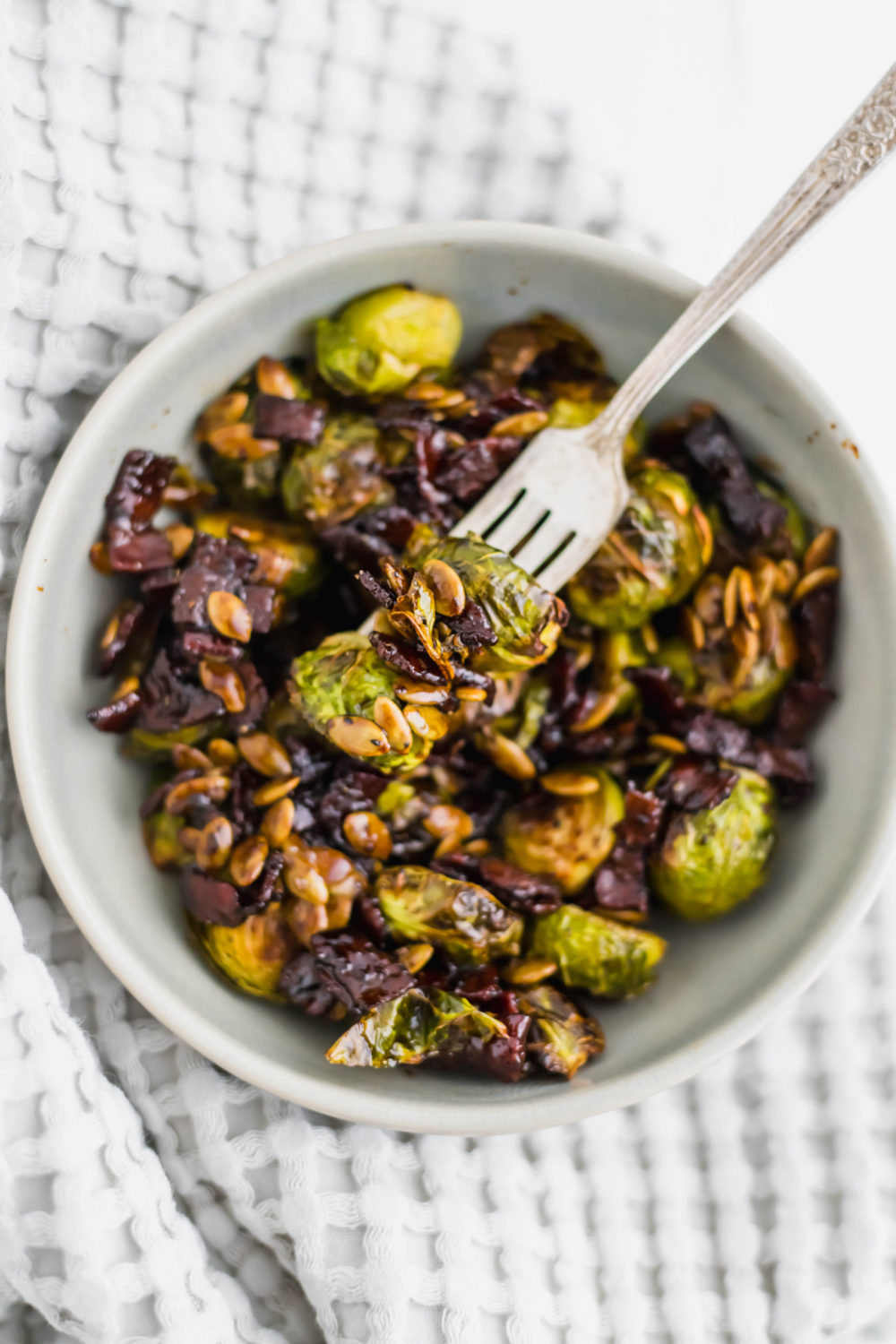 Honey Balsamic Brussels Sprouts are roasted perfectly in the oven then drizzled with the tastiest sweet and savory sauce. Topped with crispy bacon and pumpkin seeds for the perfect crunch.