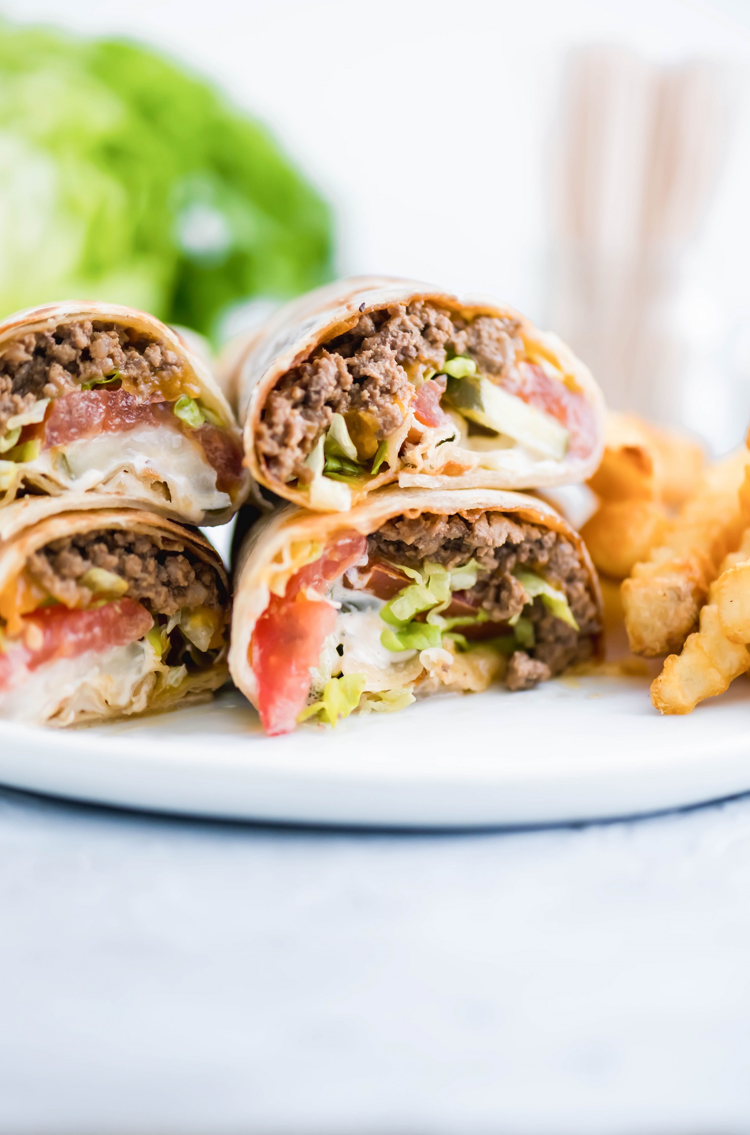 A fun twist on the classic cheeseburger, these Cheeseburger Wraps feature ground beef, cheese, burger sauce, lettuce, tomato and pickles all wrapped up in a flour tortilla.