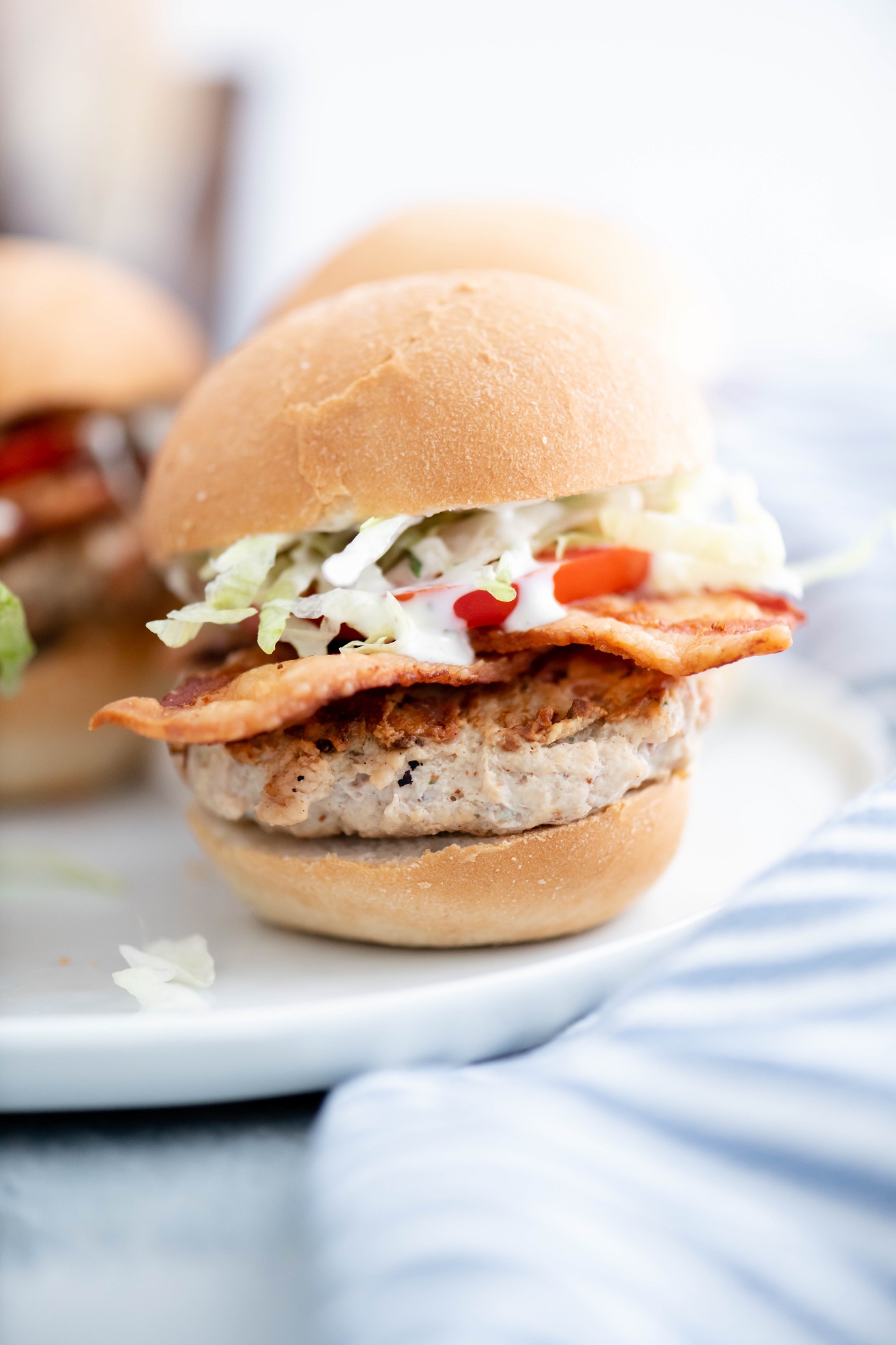 chicken bacon ranch slider on a white plate with two in the background