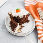 Slice of chocolate pumpkin cake on a small white plate with a bite on a fork.