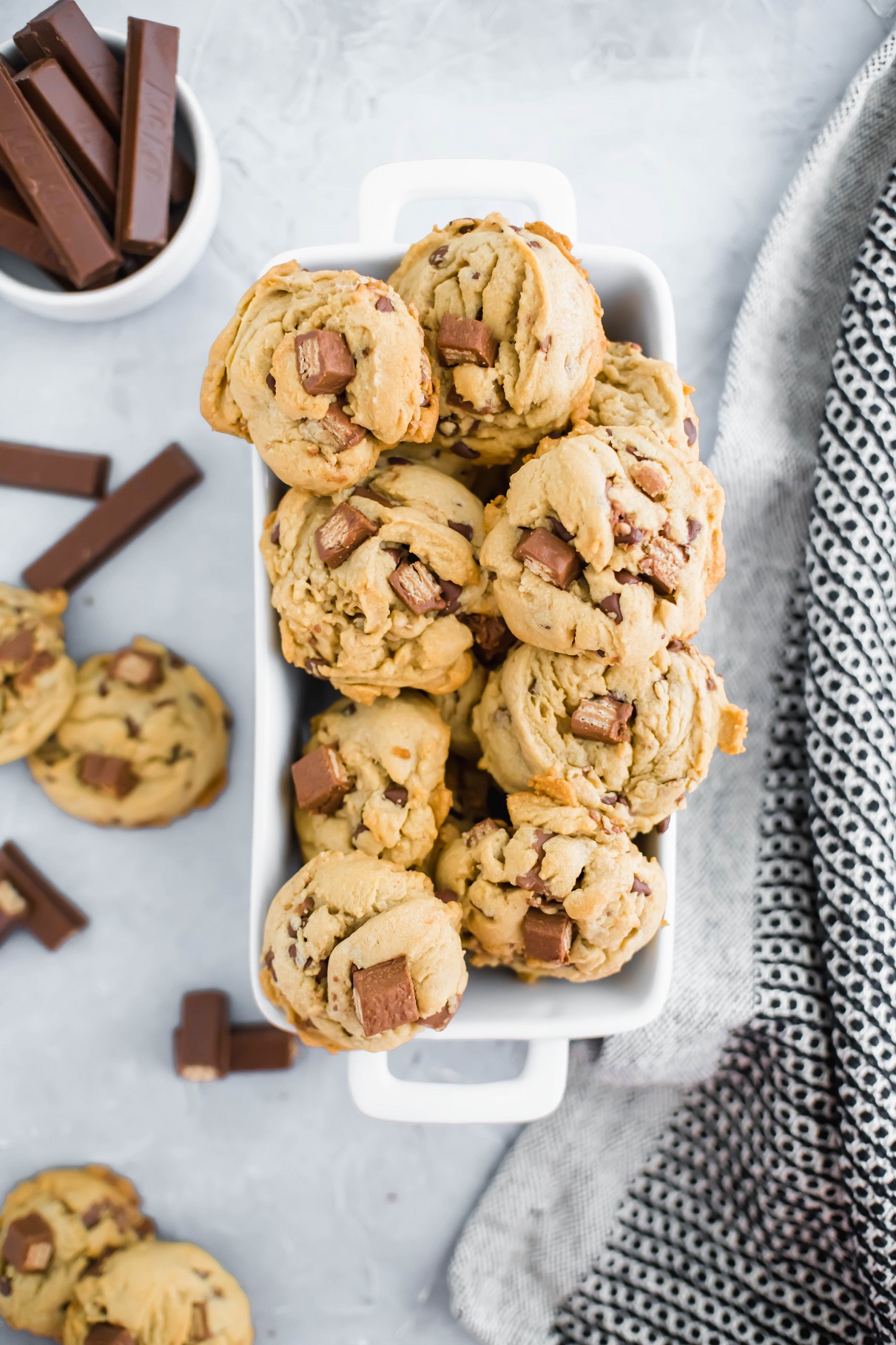 Kit Kat Cookies piled in a white baking dish. Bowl of kit kats in background.