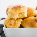 Sweet potato rolls piled in a ceramic baking dish.