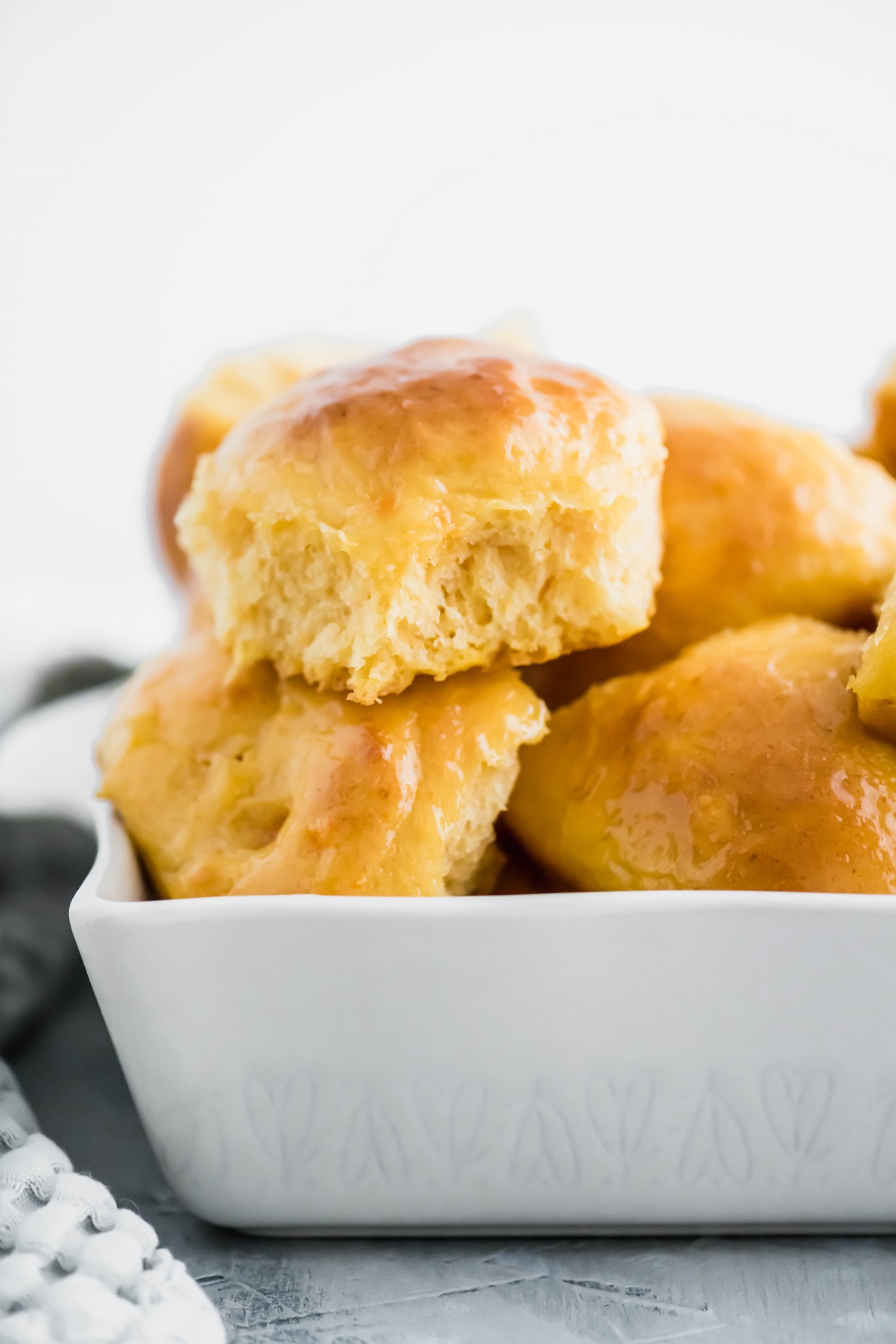 Sweet potato rolls piled in a ceramic baking dish.