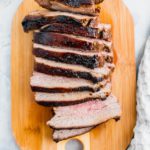 Air Fryer Tri Tip sliced and arranged on a small wooden cutting board.