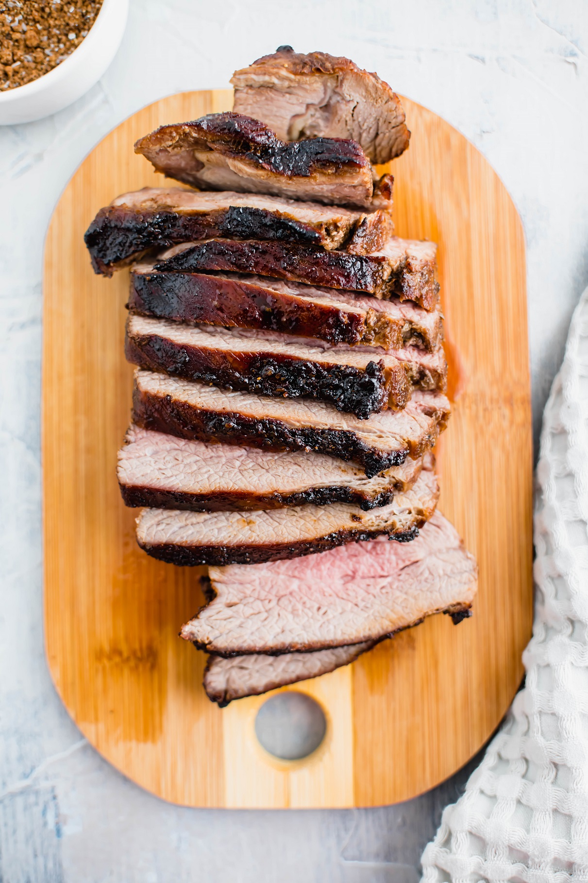 Air Fryer Tri Tip sliced and arranged on a small wooden cutting board.