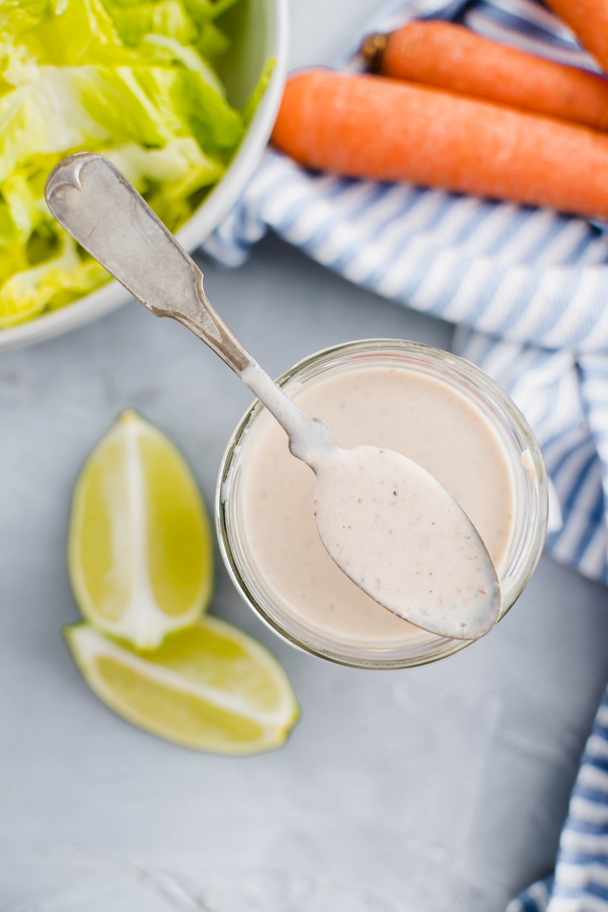 Jar of salsa ranch surrounded by fresh veggies.