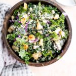 Large wooden bowl filled with chopped dill pickle salad.