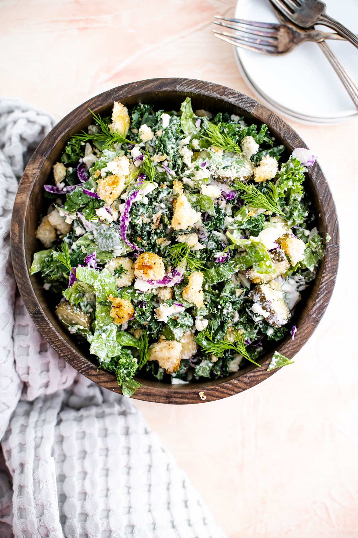 Large wooden bowl filled with chopped dill pickle salad.