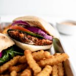 chicken sandwich on a platter with fries.