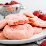 Plate of strawberry sugar cookies. One broken in half to show the pretty pink color inside.