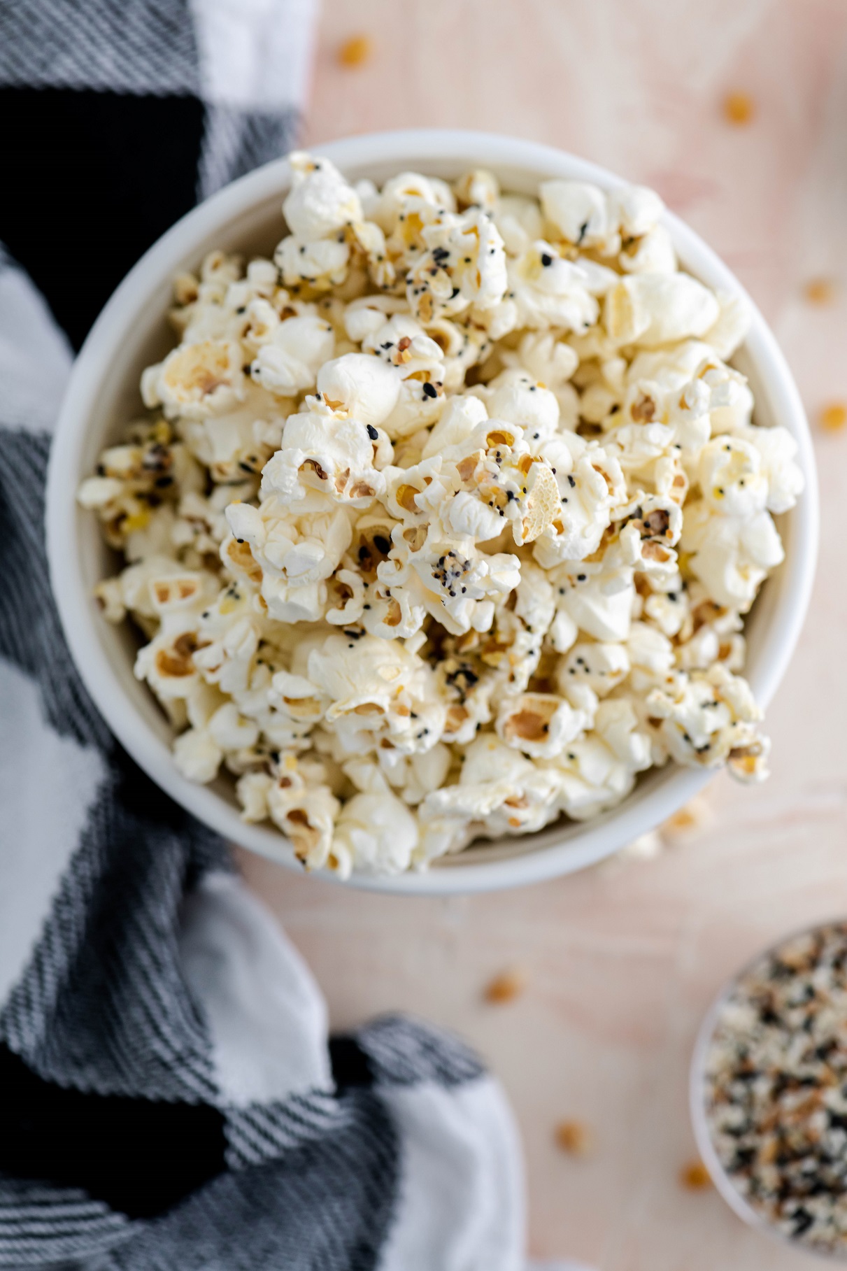 Straight down shot of everything bagel popcorn in a ceramic bowl.