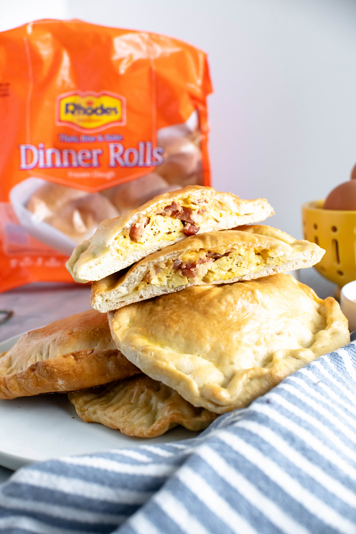 Stack of homemade breakfast hot pockets on a late. One on top cut open to show filling.