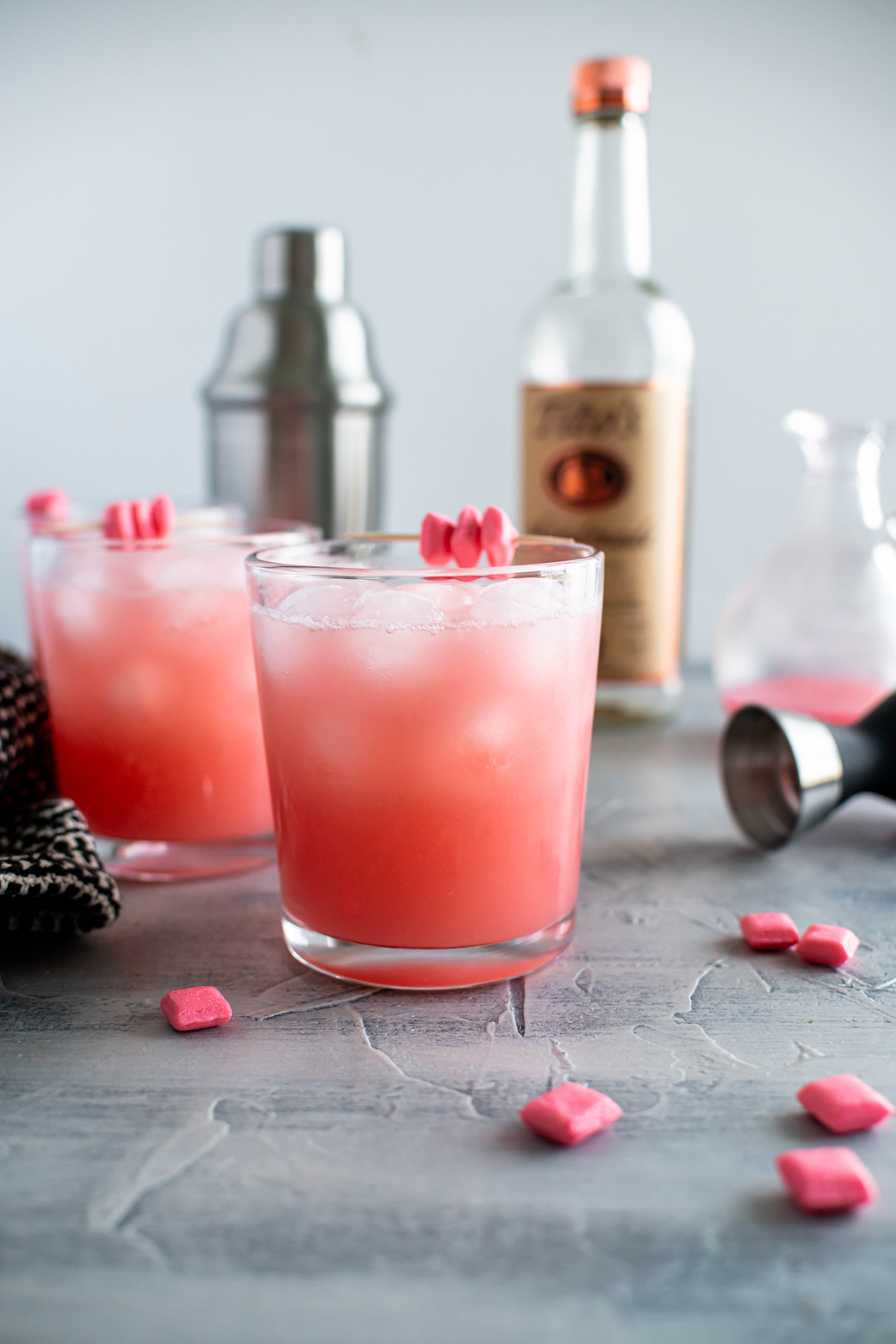 Two glasses of starburst cocktails with a shaker and a bottle of vodka in the background.