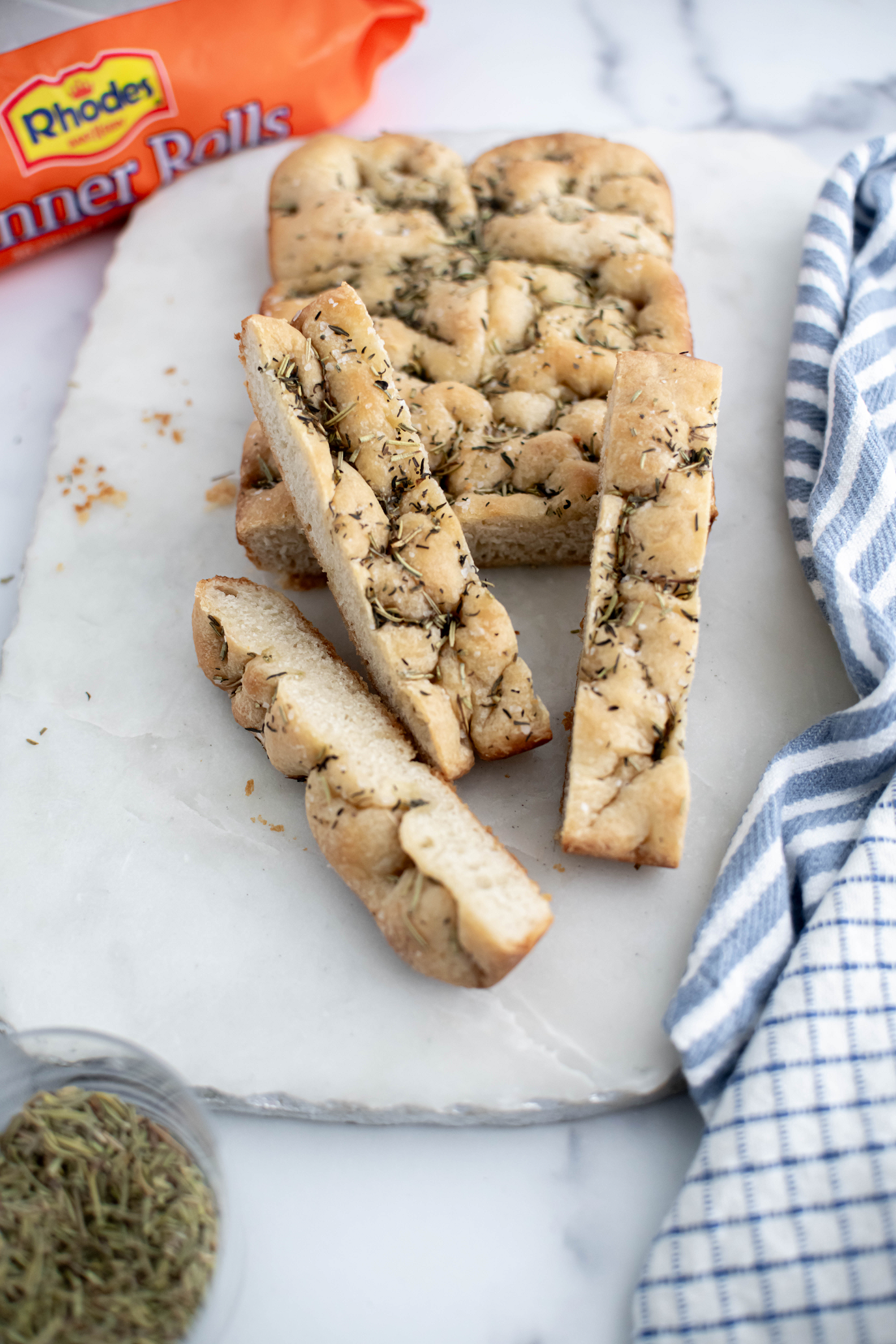 Mini focaccia on a marble board cut with a few slices arranged around.