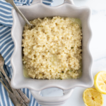 Square dish filled witth lemon couscous drizzled with lemon herb vinaigrette.